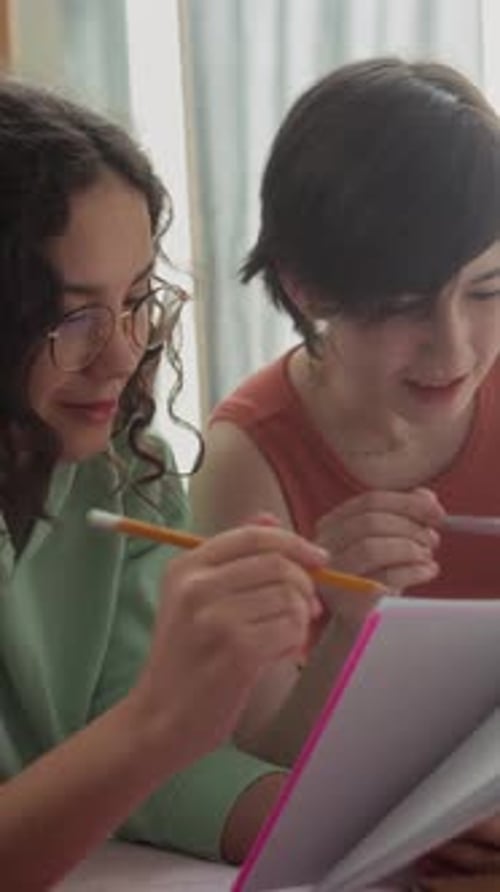 Des adolescentes discutent pensivement de leurs devoirs dans une chambre accueillante