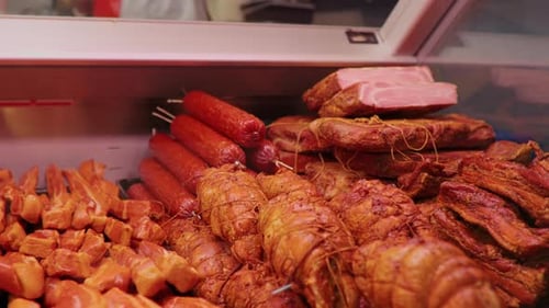Freshly smoked sausage and ham on the counter of Butchers shop.