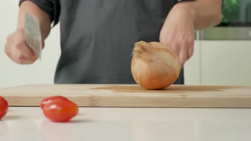 Slicing Onion on a Cutting Board in Kitchen