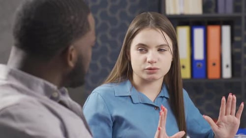 Femme d'affaires et homme d'affaires sérieuse et concentrée de différentes races parlant de travail au bureau