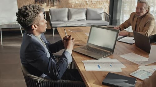 Vielfältiges Projektteam arbeitet im Besprechungsraum am Finanzbericht