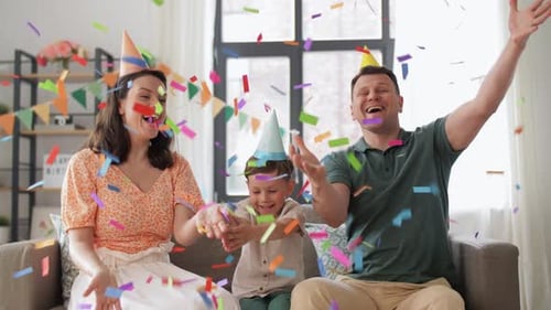 Happy Family Celebrating with Confetti at Home Birthday Party