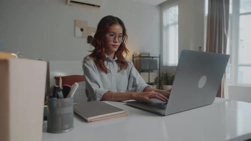 Female Student Doing Course Work Using Laptop at Home
