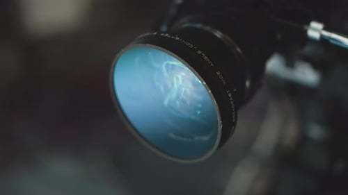 Close Up Camera Lens Reflecting Green Blue Studio Lights with Glass Elements