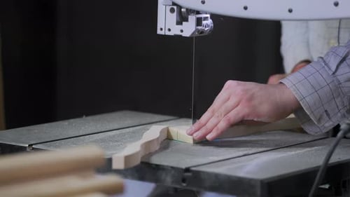 A man works with wood in a workshop. Working with wooden blanks. A man drills holes in wooden blanks
