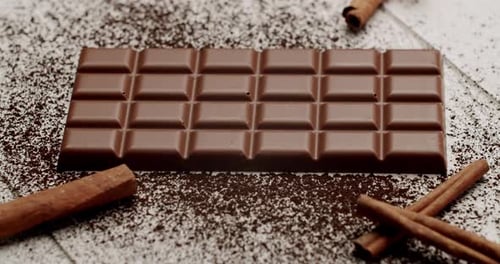 Delicious Chocolate Bar With Cinnamon Sticks On Cocoa Powder Sprinkle