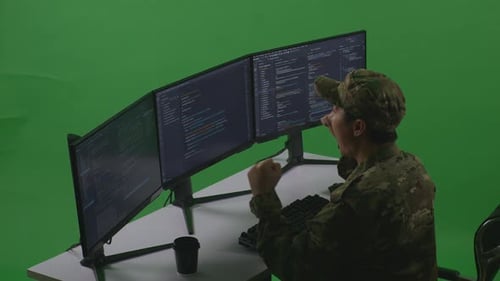 Side View Of Man Soldier Celebrating While Write Code With Multiple Computer Screens In Green Screen