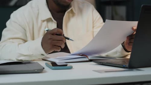 Young Adult Signs Documents at Office Desk
