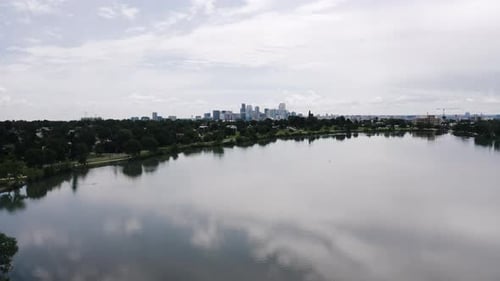 Drone shot pulling away from a distant Denver, Colorado with Sloan Lake and Penny Island in the fore