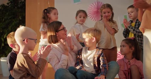 Teacher and Children Clapping Hands in Classroom