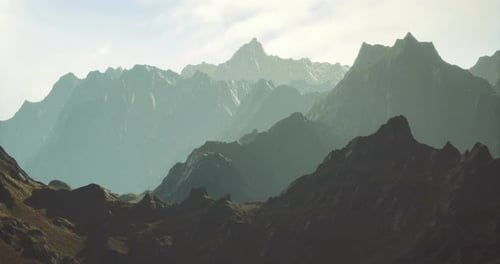 Majestic Mountain Range Bathed in Soft Sunlight During Early Morning Hours