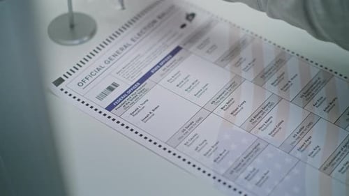 Hand Marking Presidential Election Ballot at Table