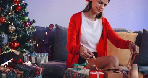 Young Woman Wrapping Christmas Gifts at Home