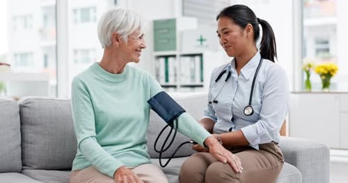 Doctor Examines Senior Woman with Blood Pressure Cuff