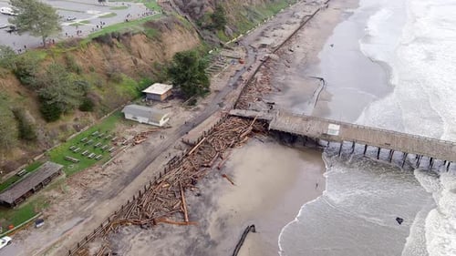 Logs Littering On The Shoreline Of Seacliff State Beach After Raging Storm Hit California In January
