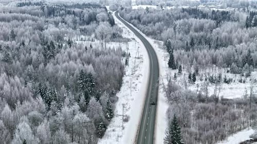 Fahrt durch verschneite Landschaft auf einer kurvenreichen Autobahn im Winter