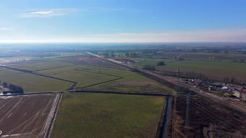 Luftaufnahme eines Zuges, der durch Ackerland in Norditalien, Lombardei
