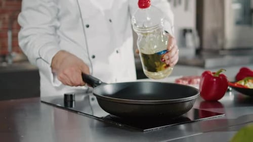 Starting the Cook Pouring Oil into a Hot Pan on the Stove