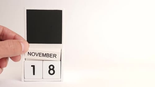 Hand Adjusting November 18 Date on Block Calendar