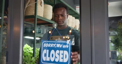Happy, open sign and black man by door in store for sustainability, plants