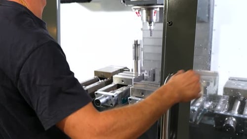 Operator Opening Milling Machine Door in Factory