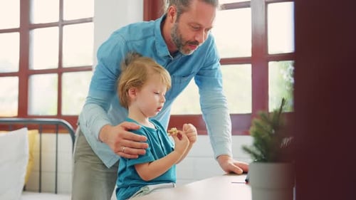 Dad and Son Sharing a Snack Indoors