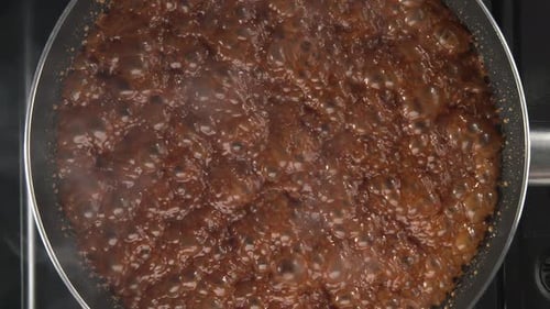 Bubbling Brown Liquid Cooking in a Frying Pan