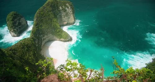 Green cape on tropical Island Bali Kelingking Beach Indonesia. Azure ocean waves on pristine sandy s