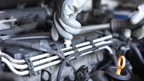Mechanic with screwdriver working on car engine, closeup. Replacing auto parts