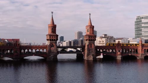 Iconic Oberbaum bridge spanning River Spree, subway train crossing over; aerial