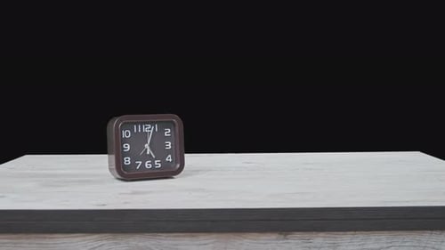 The Pointer Clock on Wooden Table and Black Background Show Time