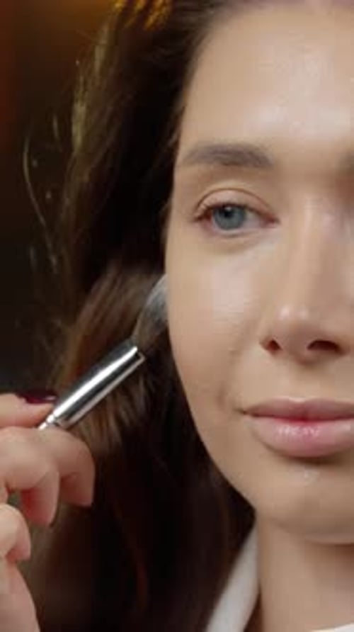 Woman Applying Makeup with Brush in Close-Up