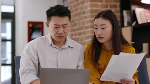 Colleagues Reviewing Documents on Laptop Together