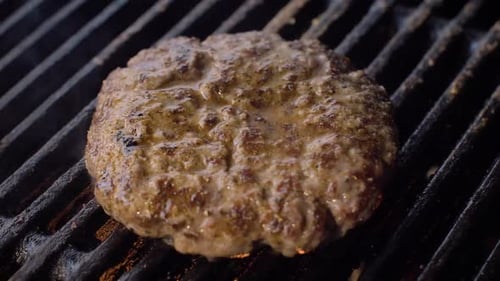 Chef Cooking Beef Patty for Burger on Hot Grill and Flip the Cutlet with a Spatula