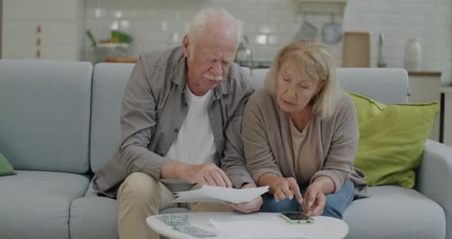 Stressed Retired People Counting Rent and Household Payments Paying Bills Using Smartphone