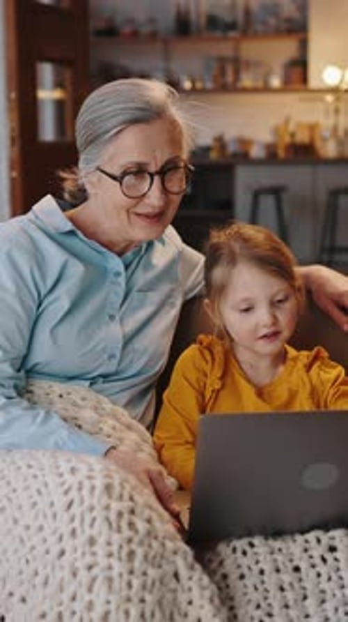 Grandmother and Child Enjoying Laptop Indoors Together