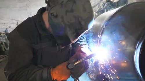 Schweißer, der die Verbindung zwischen zwei Stahldetails herstellt