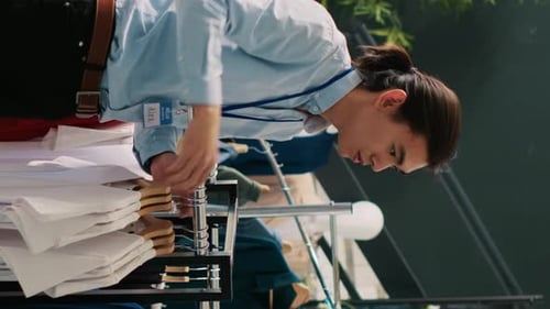 Young Adult Employee Organizes Clothing in Urban Store