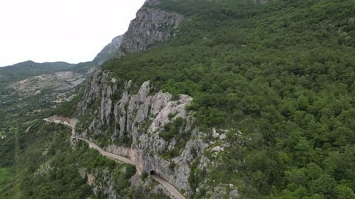 Beautiful mountain road passing along the big green mountains. Aerial view. Montenegro.