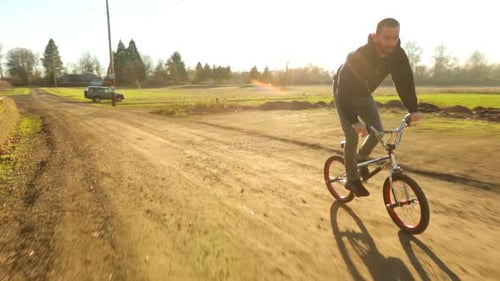 Young man on bicycle performing urban stunts in warehouse for sport and recreation