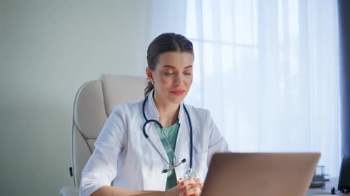 Medic Talking Online Consultation Looking Laptop Screen in Clinic Office Closeup