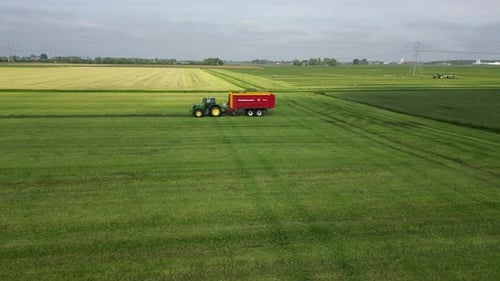John Deere tractor with trailer on harvest. John Deere tractor with harvester, Netherlands