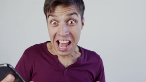 Man Reacts to News on Smartphone