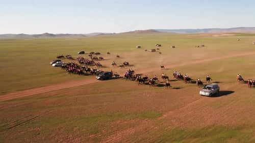 Mongolian horseback riders training for a horserace in Mongolia called Naadaam galloping across the