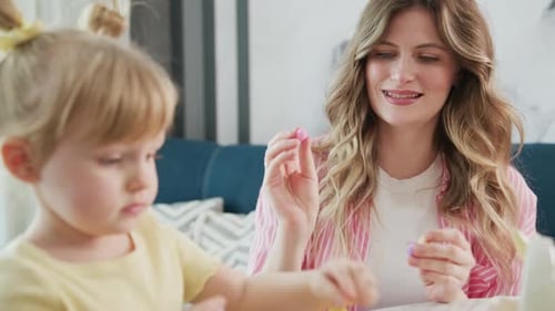 Smiling Woman and Child Crafting Together at Home