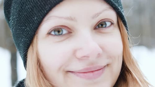 Portrait of Beautiful Smiling Winter Girl in Black Hat Looking at Camera