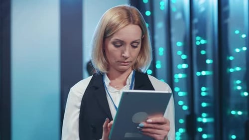 Woman Uses Tablet in Futuristic Server Room