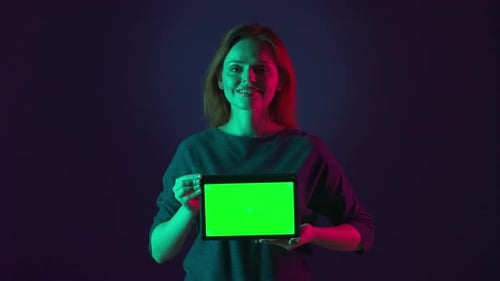 A Woman Shows a Close Up of a Green Tablet Screen Portrait of a Woman Using a Tablet with a Green