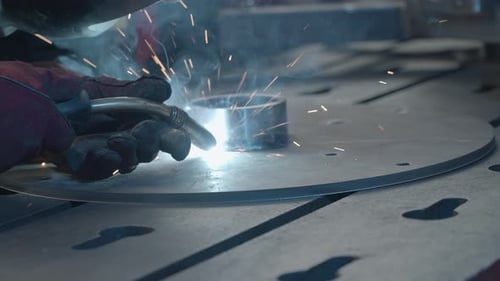 Person Welding Metal Ring to Metal Disk