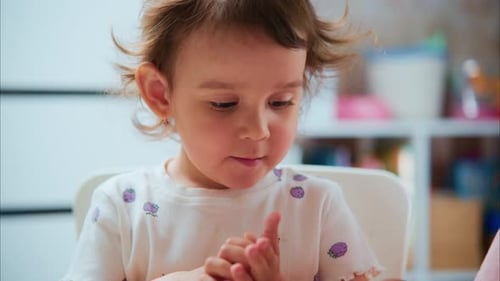 Focused Toddler Plays with Modeling Clay with Adult